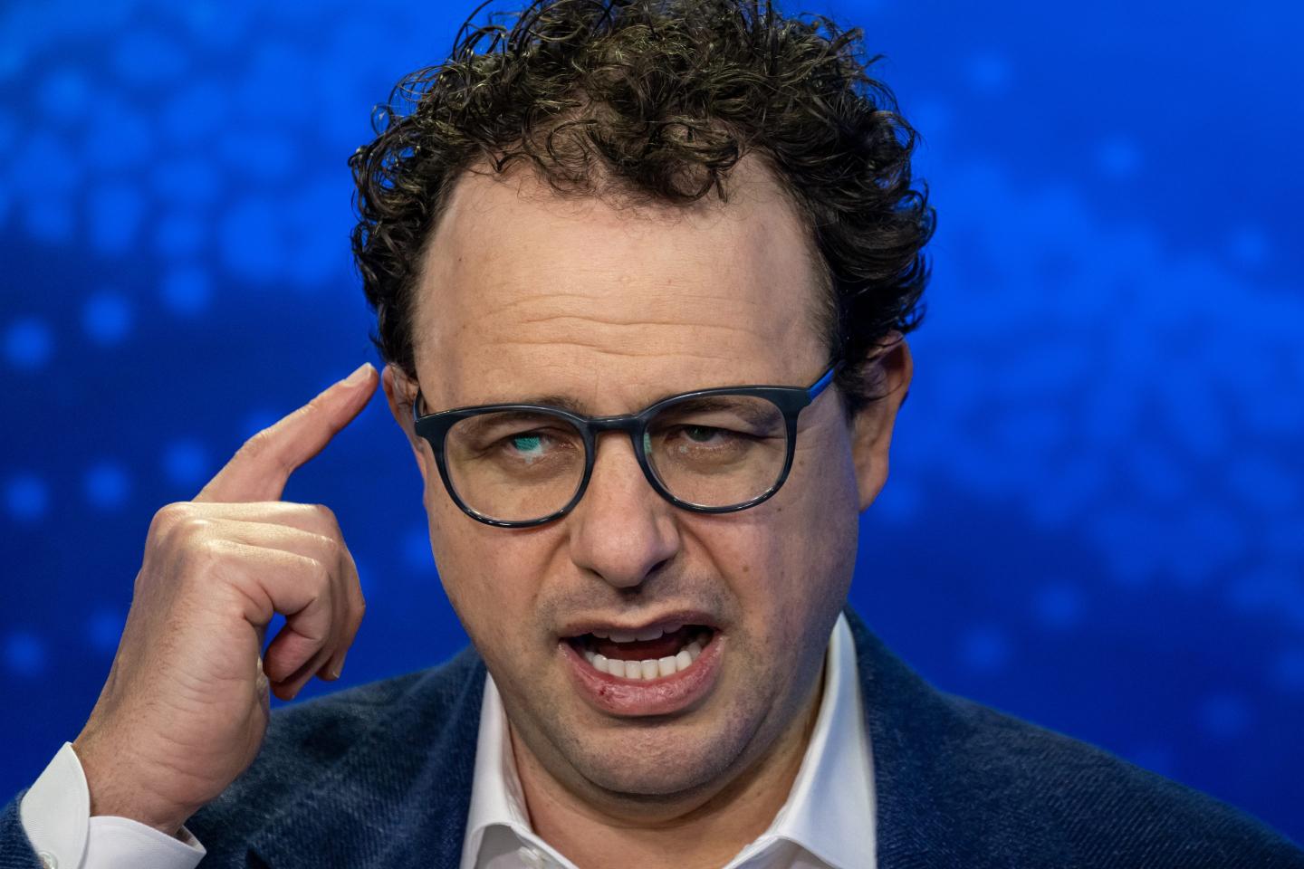 Anthropic CEO Dario Amodei pointing to his head.