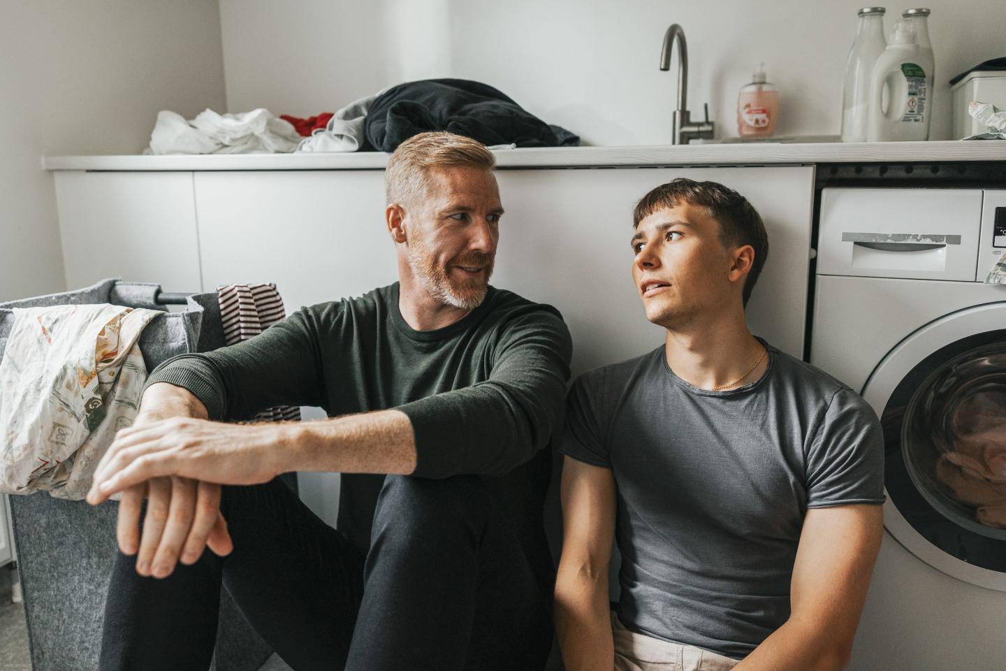 Reassuring dad sits with frustrated adult son