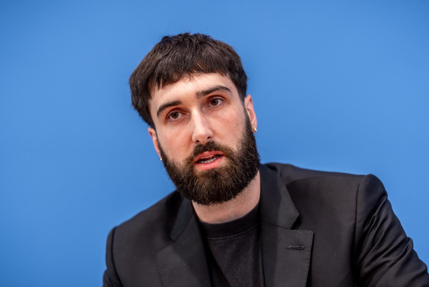 Aidan Gomez with a blue background.