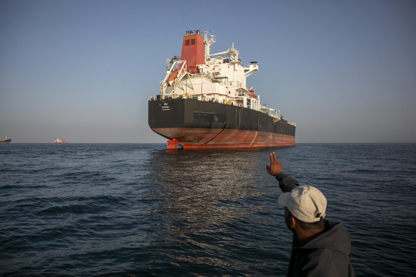 A man guides a ship in the water.