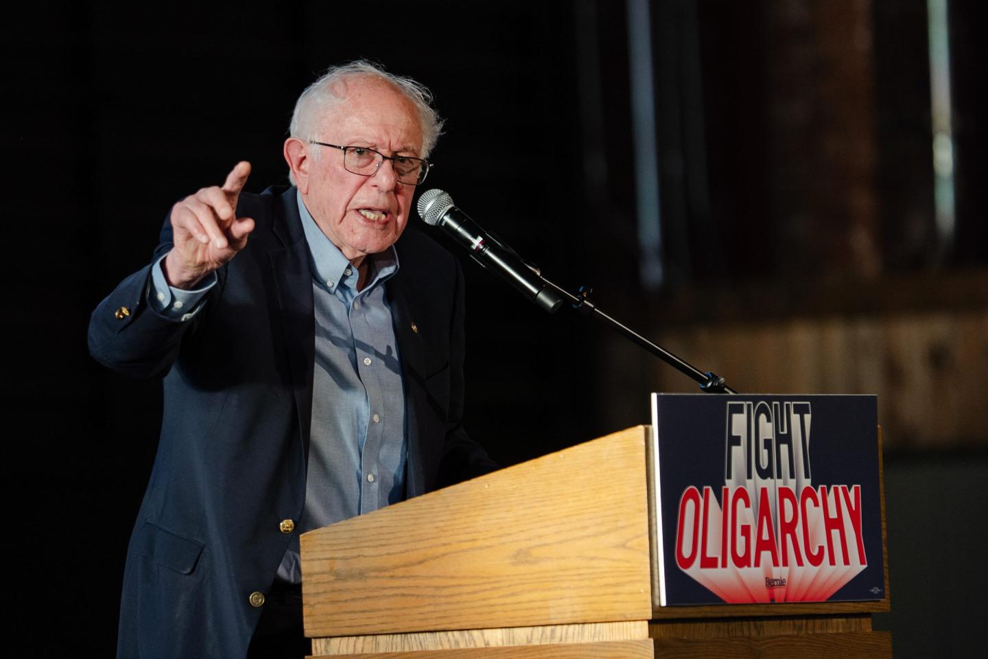 Sanders stands at a podium with a poster that reads "fight oligarchy"