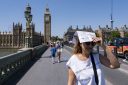 Woman hides from the sun in front of Big Ben in London