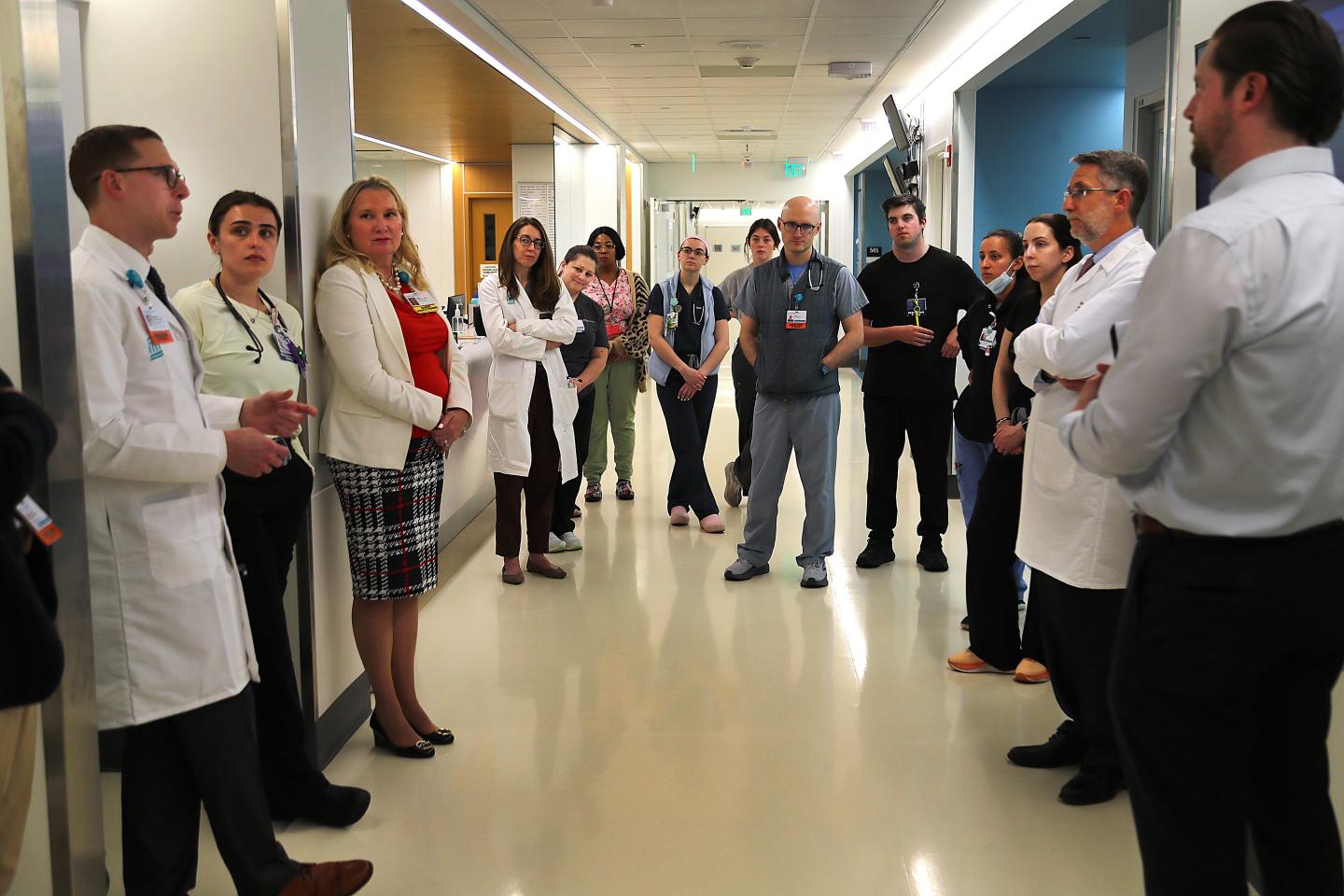 Doctors and nurses huddle in a hospital hallway