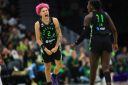 Natisha Hiedeman, wearing a black and green jersey, celebrates on court.
