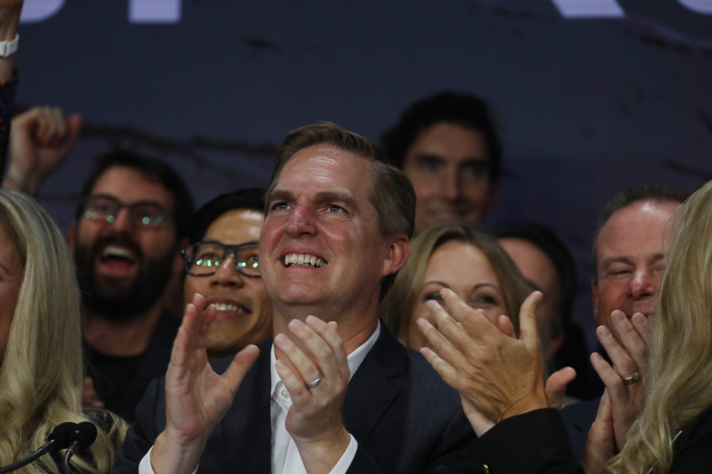 Bret Johnsen looks up, smiling, as he claps his hands.