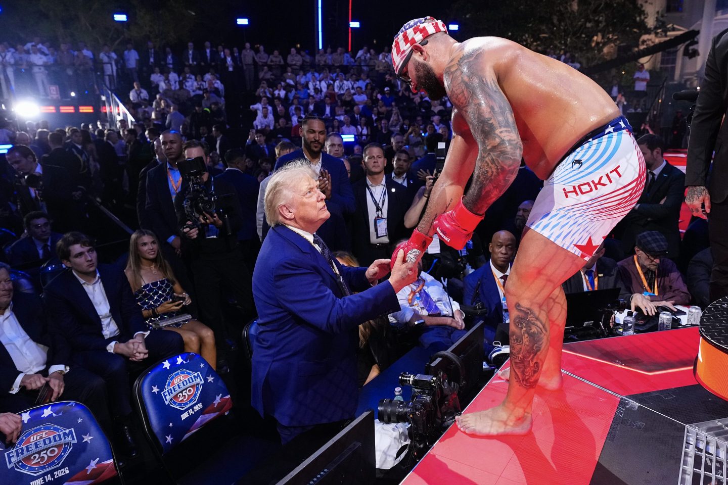 President Donald Trump shakes hands with American mixed martial artist Josh Hokit as Hokit stands on the edge of the UFC ring during a championship event at the White House.