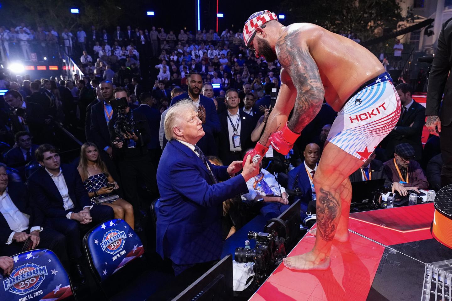 President Donald Trump shakes hands with American mixed martial artist Josh Hokit as Hokit stands on the edge of the UFC ring during a championship event at the White House.