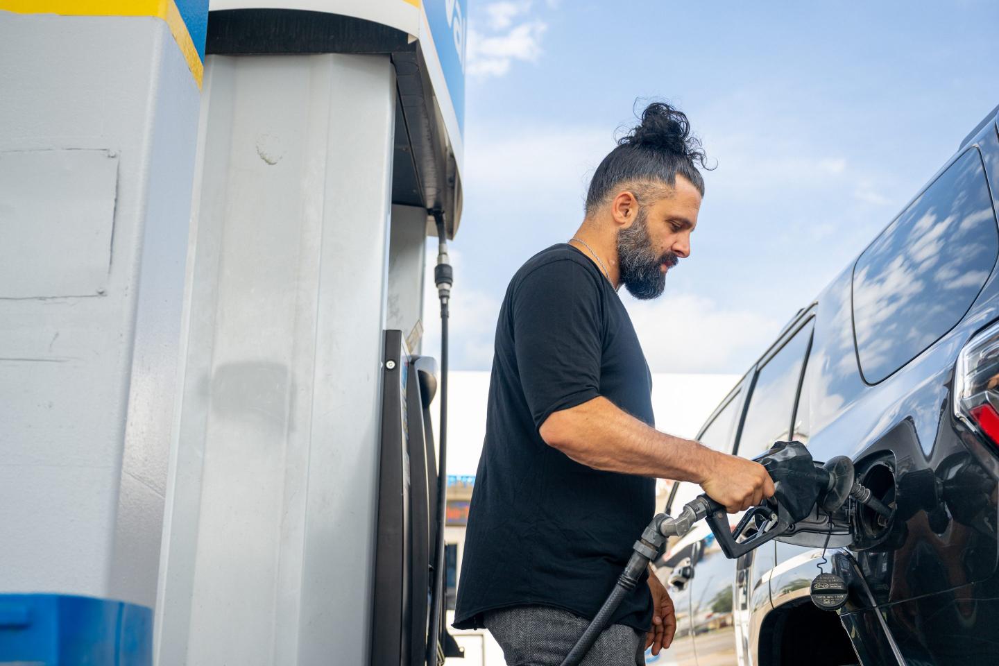 A man pumps his car with gas.