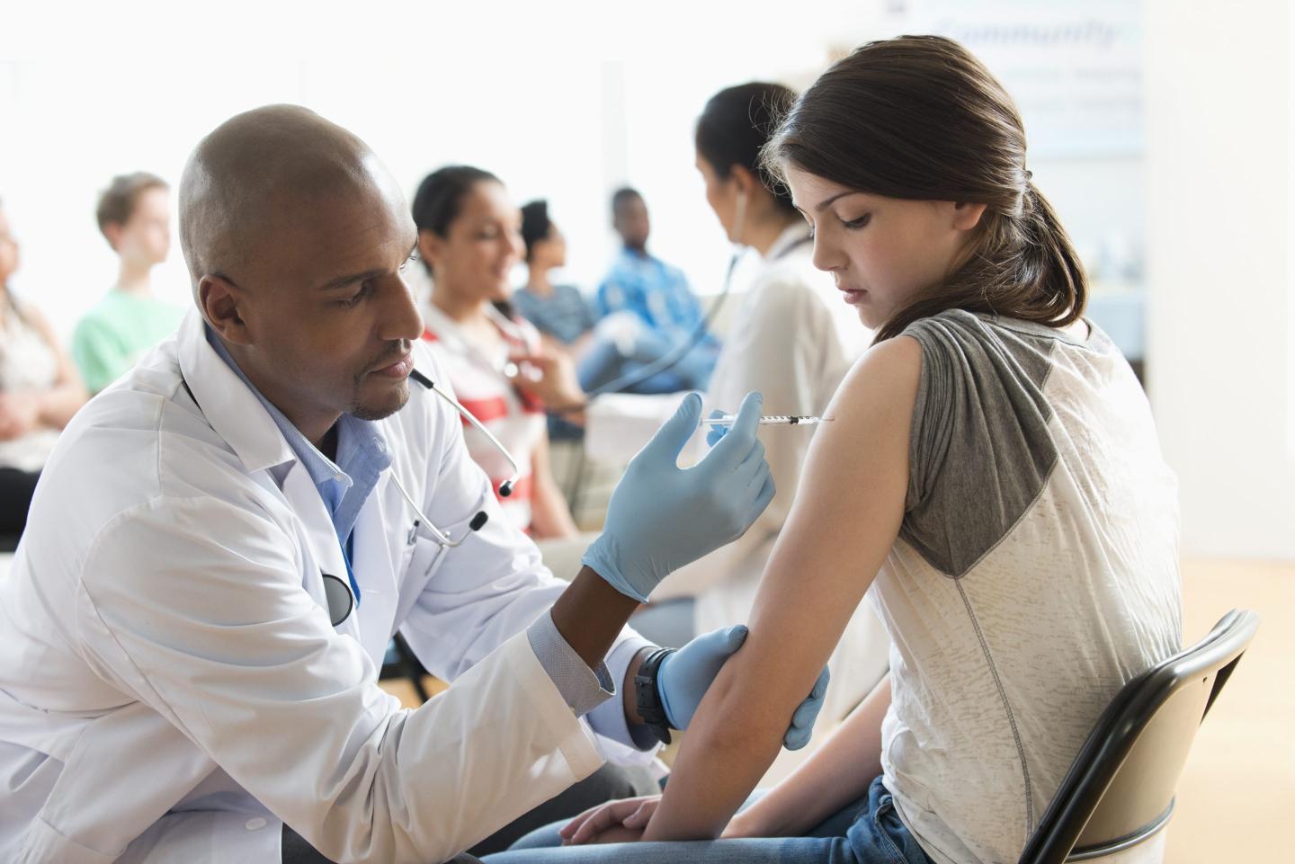 Doctor giving patient injection in volunteer clinic