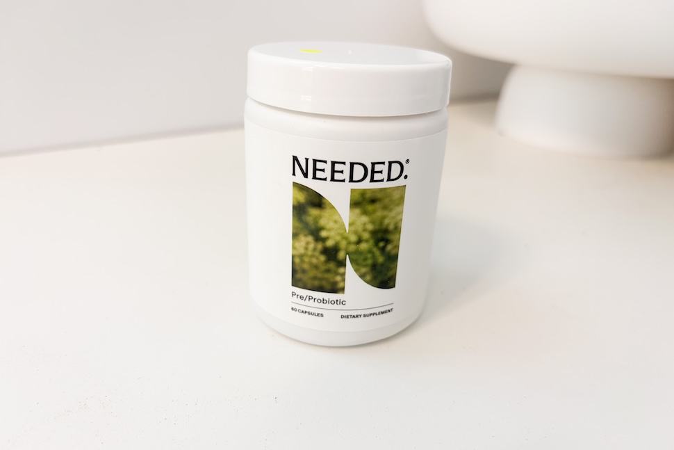 A bottle of Needed Pre/Probiotic capsules sitting on a white countertop