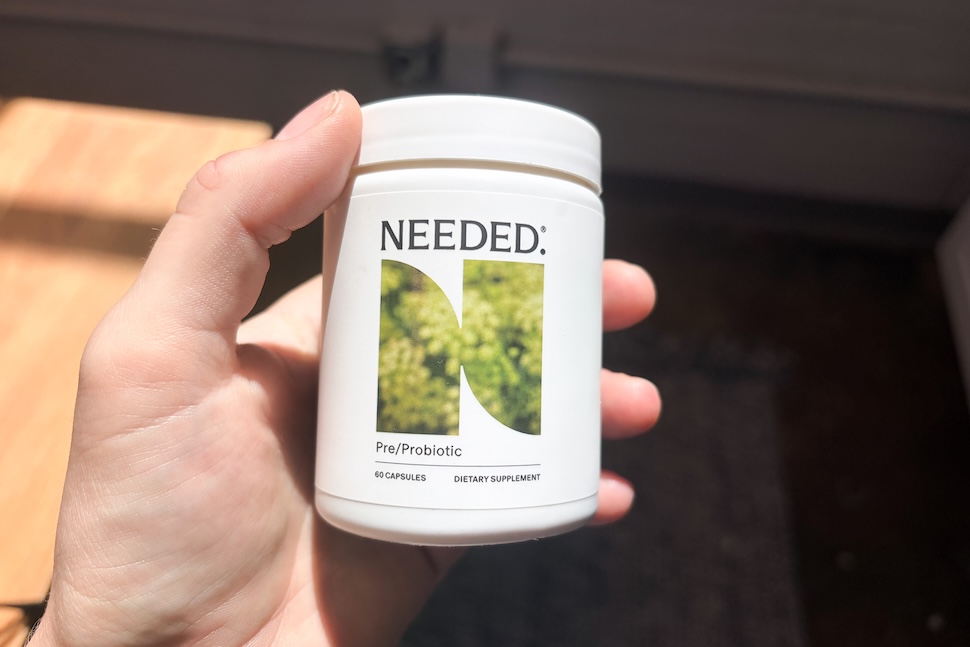 Closeup of a hand holding a bottle of Needed Pre/Probiotic