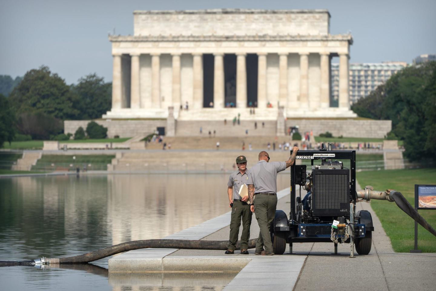 National Park Service workers stand near a pump placed next to the Lincoln Memorial Reflecting Pool, Friday, July 10, 2026.