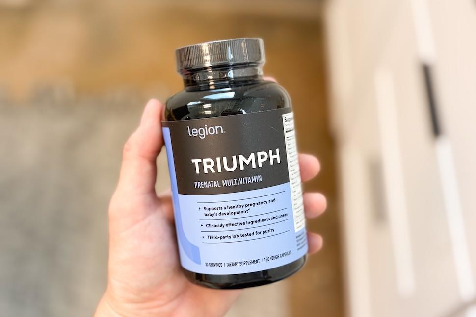 Closeup of a hand holding a bottle of Legion Triumph Prenatal Vitamins