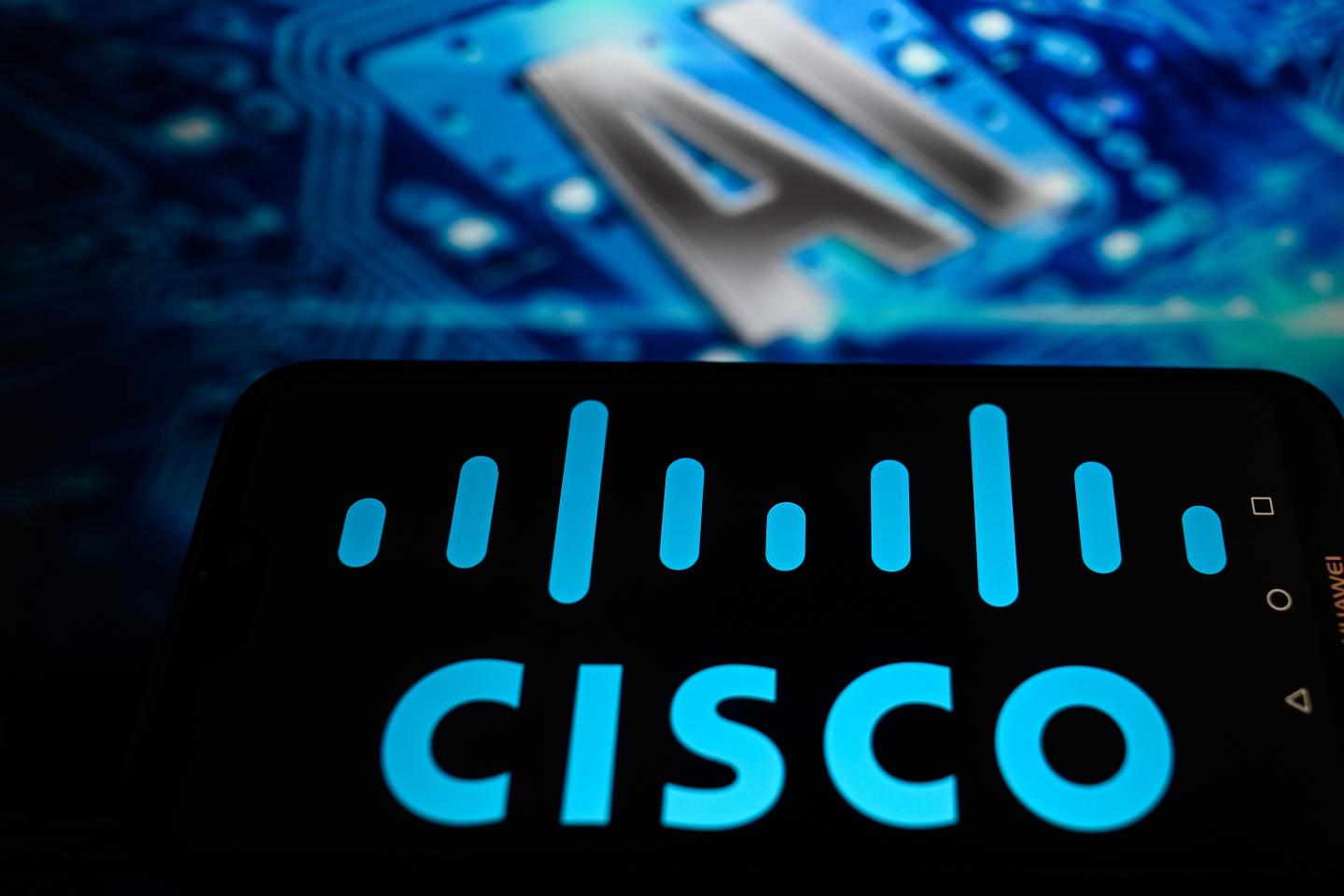 In this photo illustration, a Cisco logo is displayed on a smartphone with Artificial Intellingence (AI) symbols in the background.