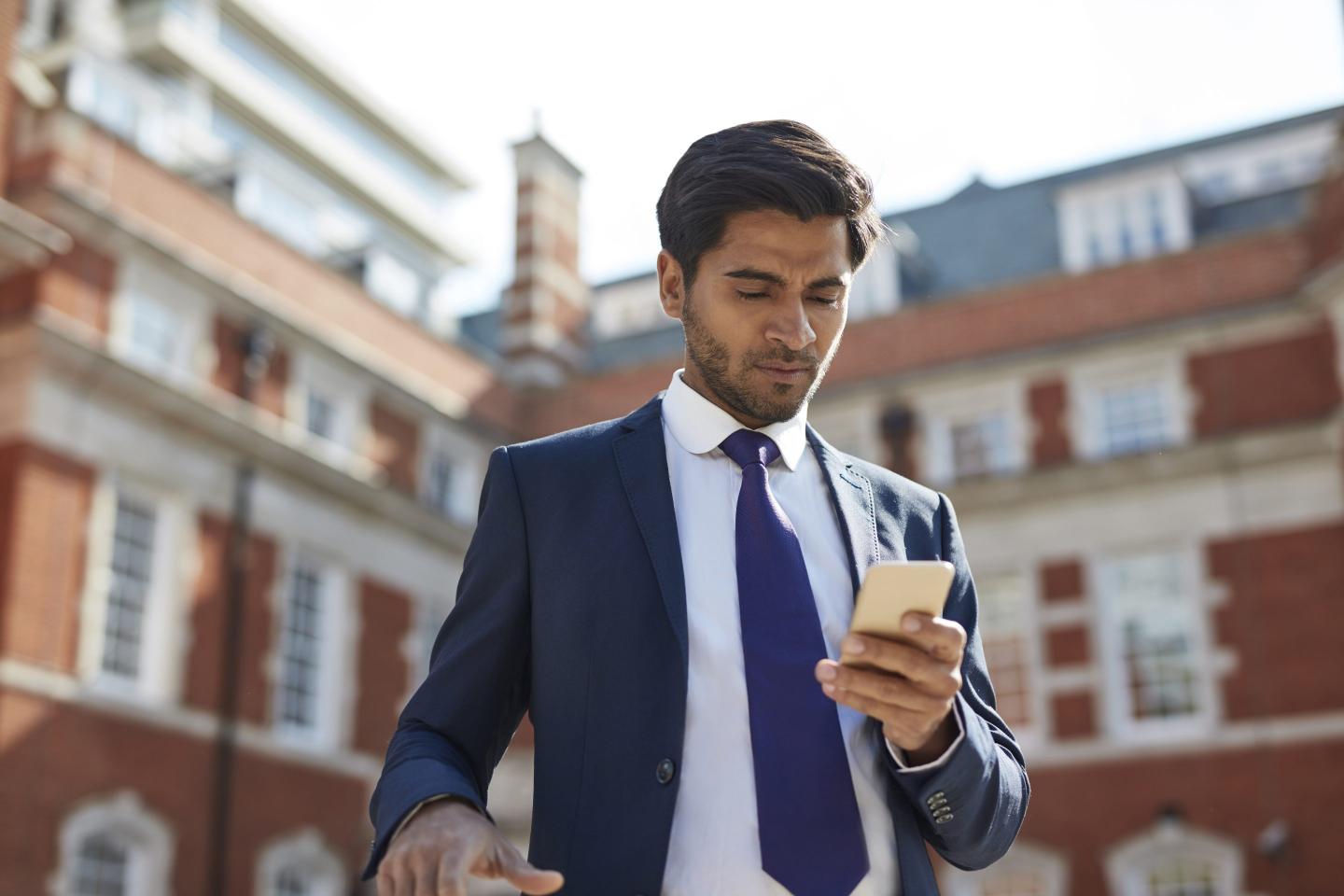 Businessman text messaging on smart phone