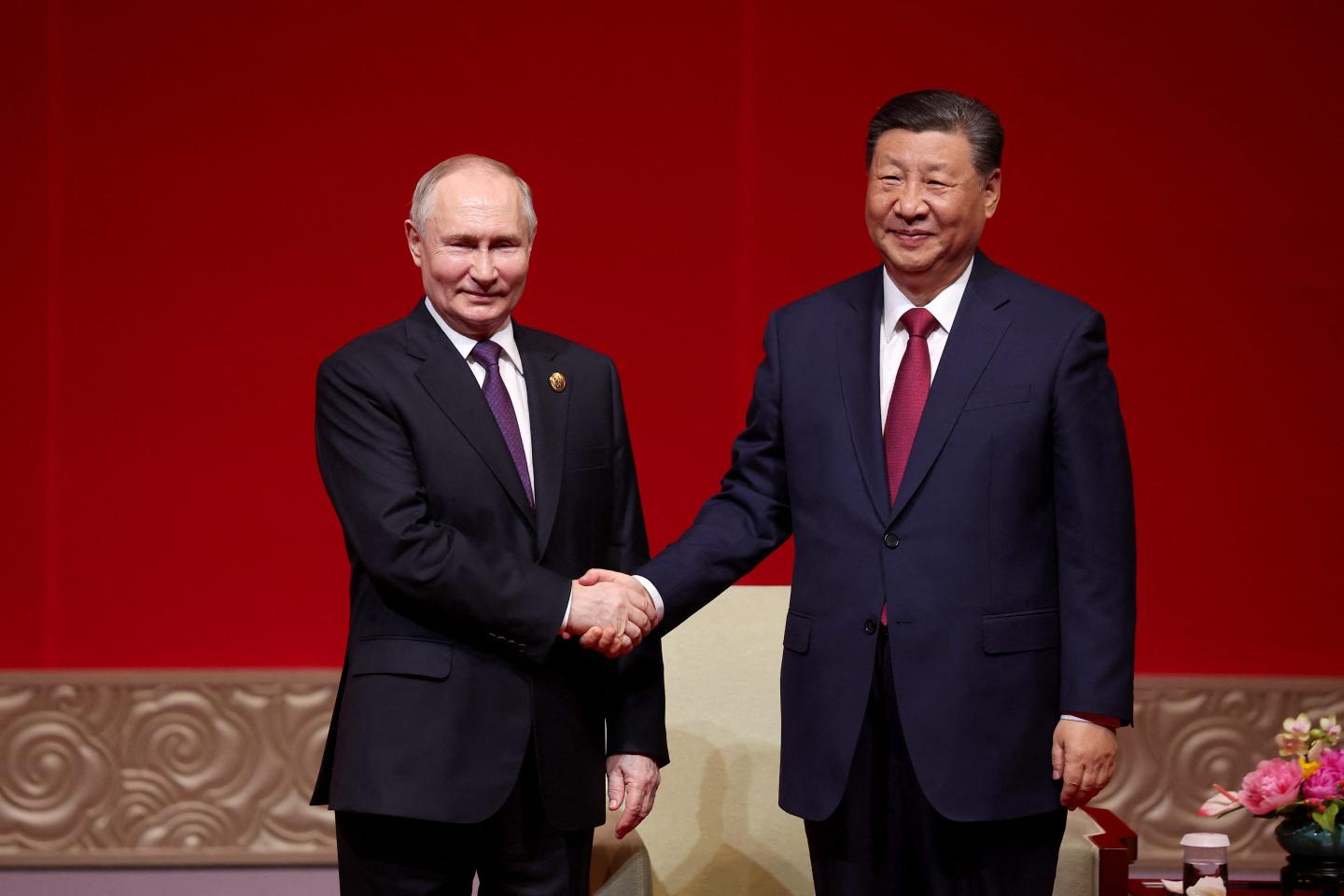 Vladimir Putin and Xi Jinping shaking hands