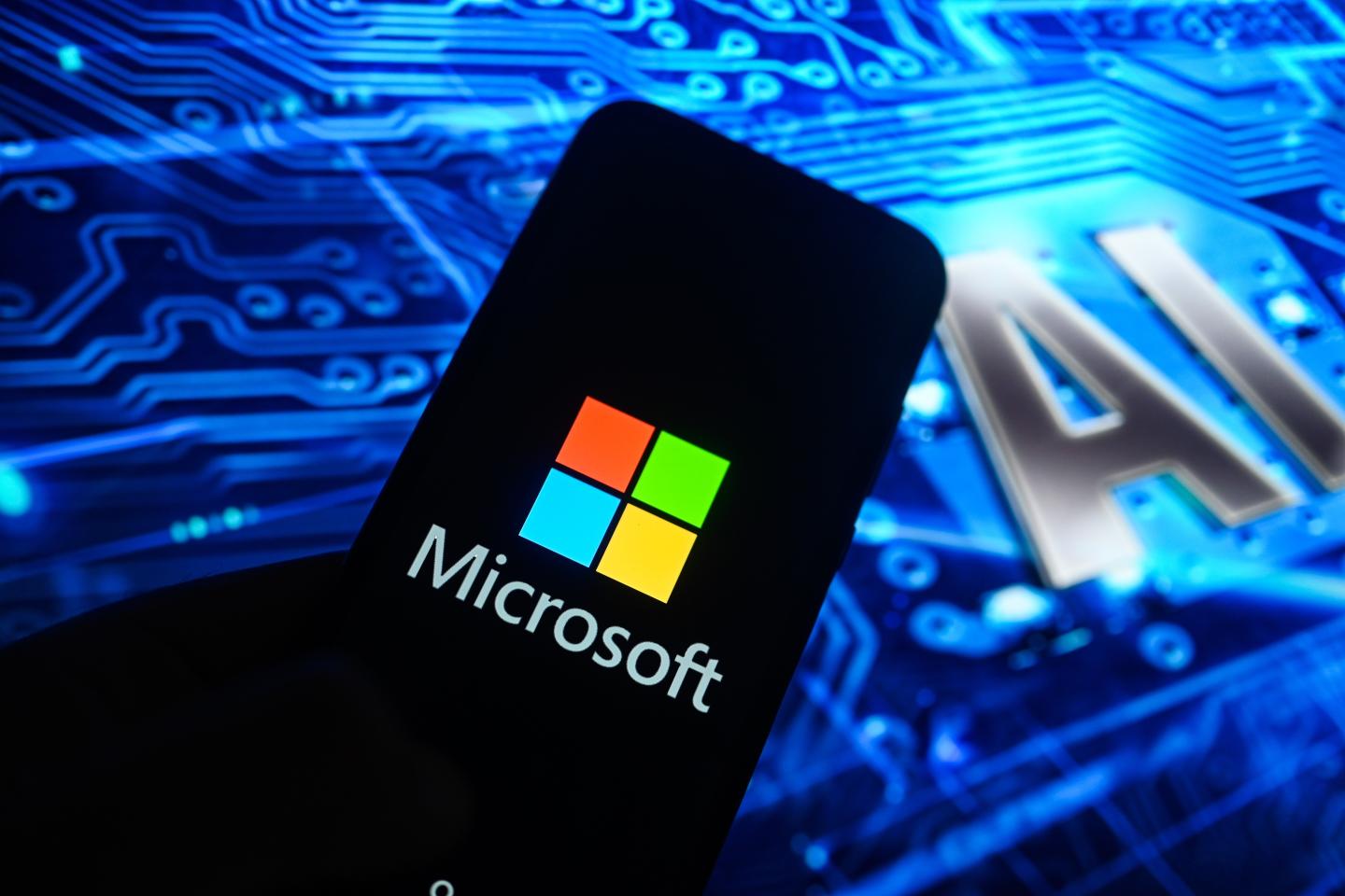In this photo illustration, a Microsoft logo is displayed on a smartphone with Artificial Intelligence (AI) symbols on the background.