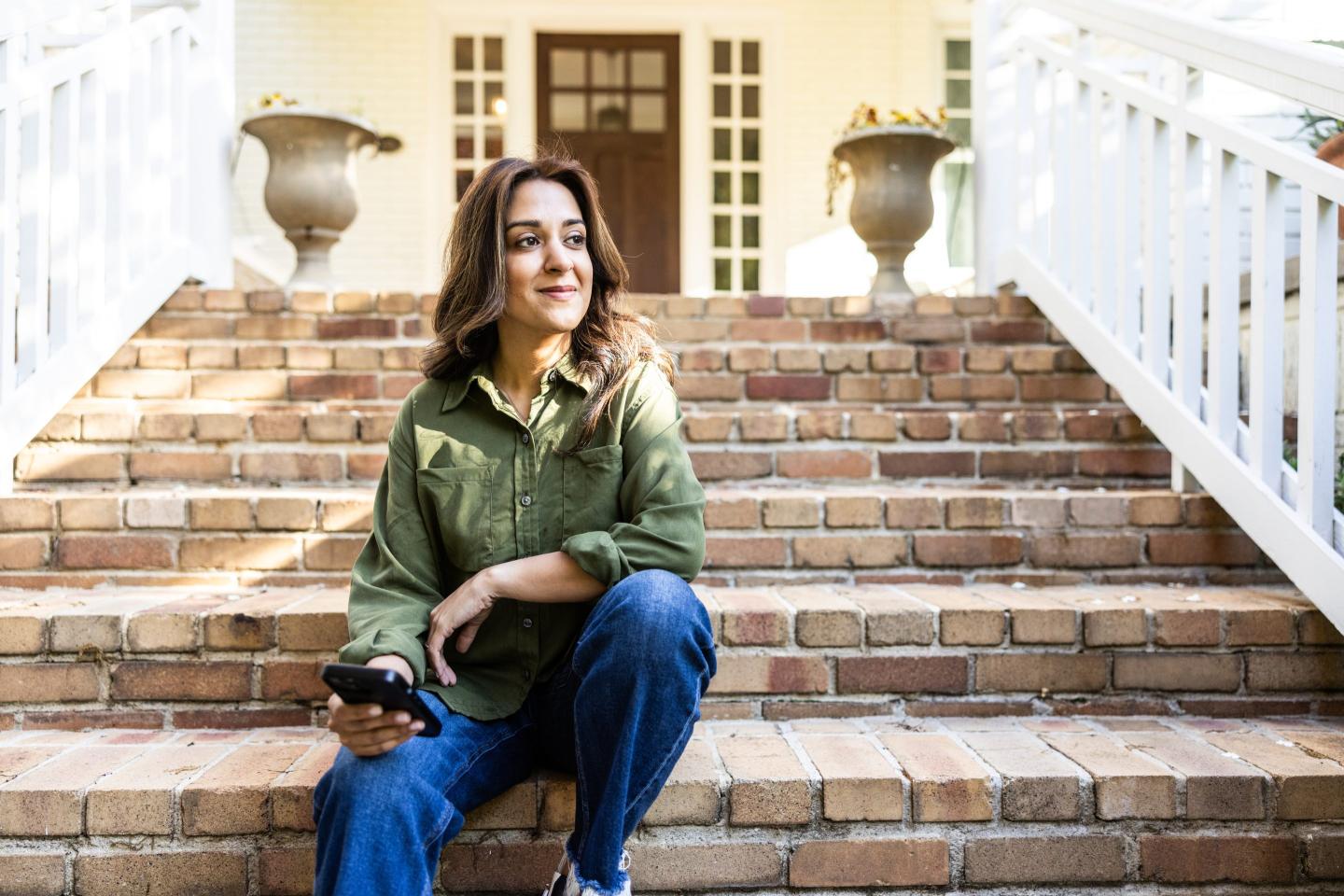 Woman sitting in front of her house