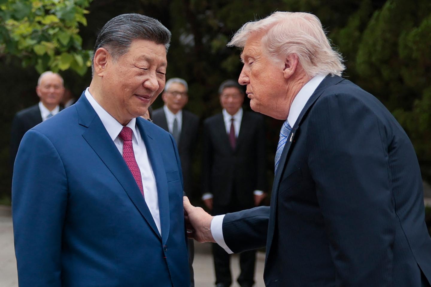 Donald Trump looks at Xi Jinping and puts a hand on his arm.