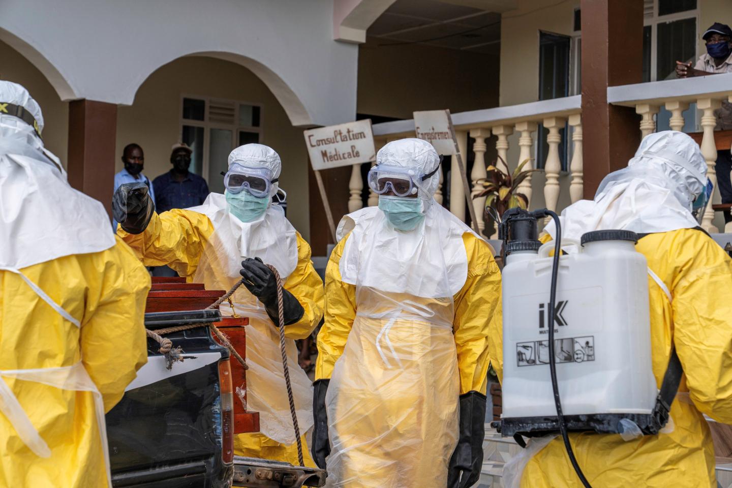 Medical workers wear protecting coverings that are white and yellow.