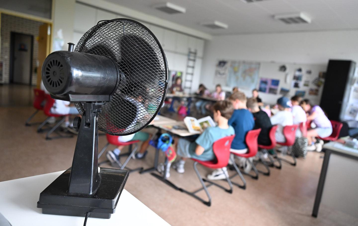 A fan is pointed towards a classroom full of students in a school.