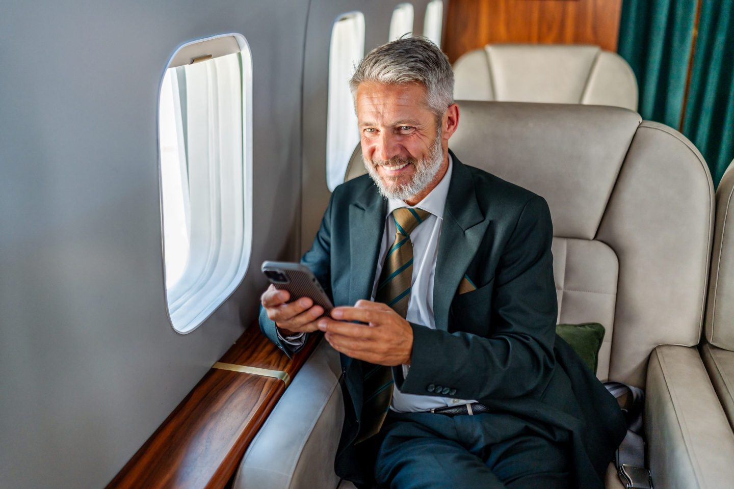 Businessman flying private jet using smartphone