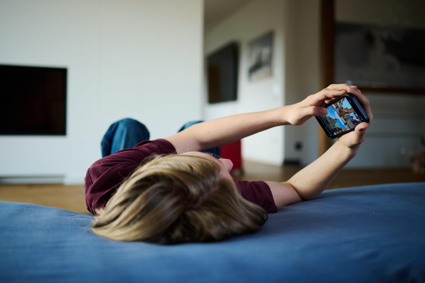 kid lying down on phone