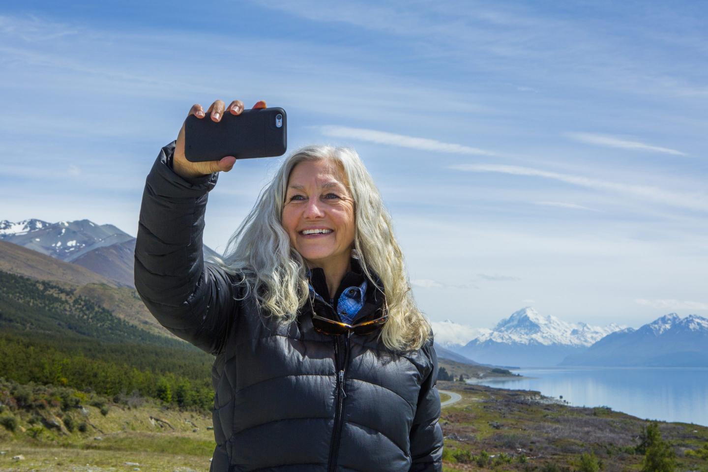 Woman taking photo in scenic landscape