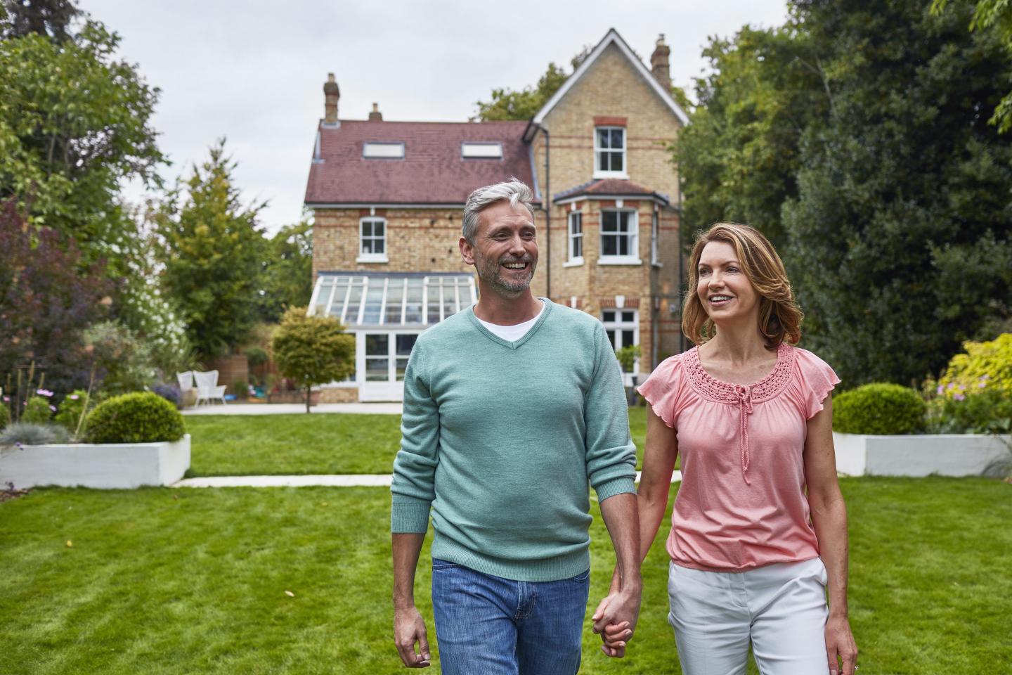 American couple walking in front of London mansion