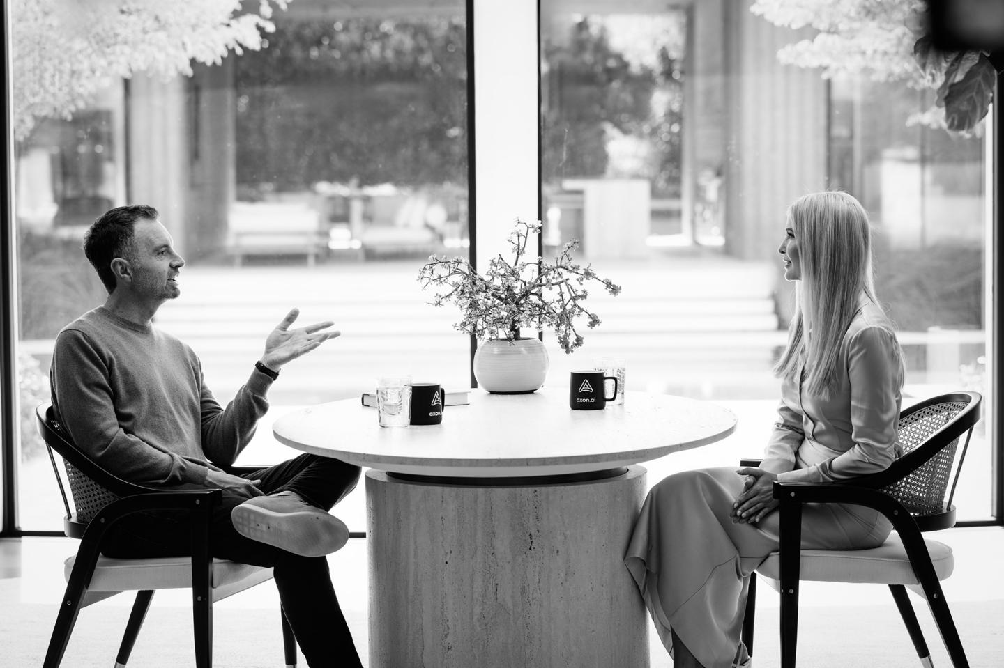 David Senra (left) and Ivanka Trump (right) sit across from each other at a table talking.
