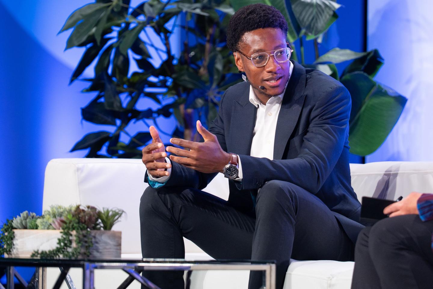 Red Lobster CEO Damola Adamolekun on stage siting on a couch