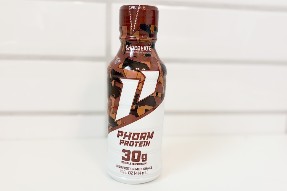 A bottle of chocolate-flavored 1st Phorm Protein sitting on a white countertop.