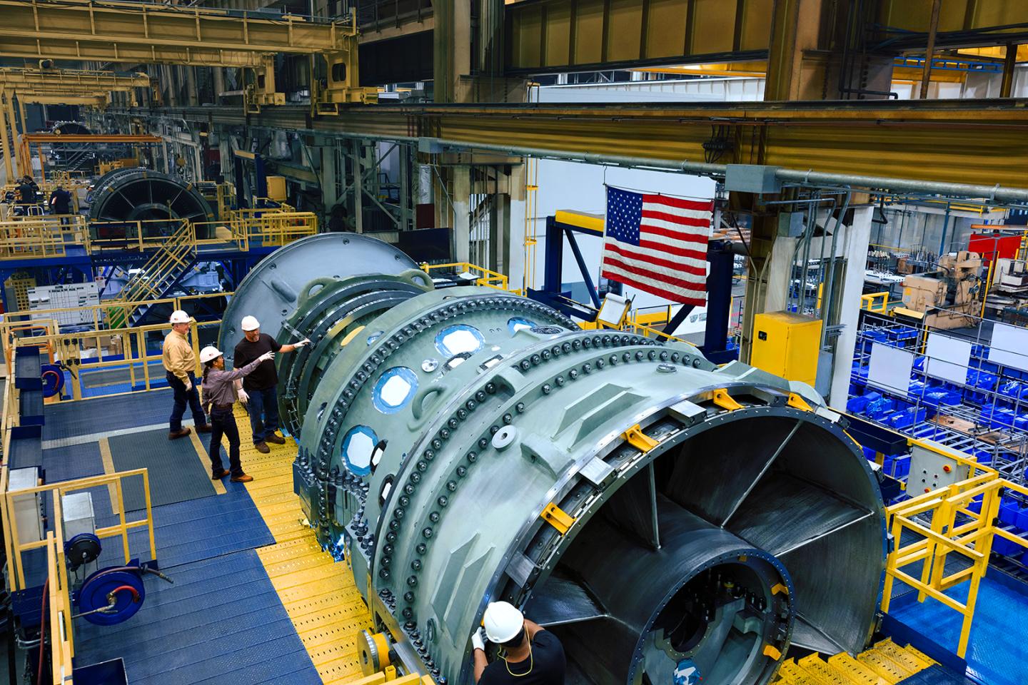 Chevron employees examine a new GE Vernova gas turbine.