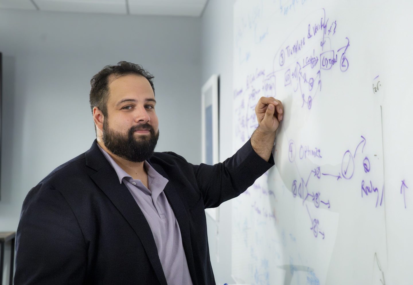 Peter Morales with his hand on a white board