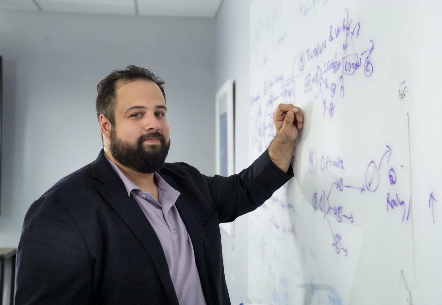 Peter Morales with his hand on a white board