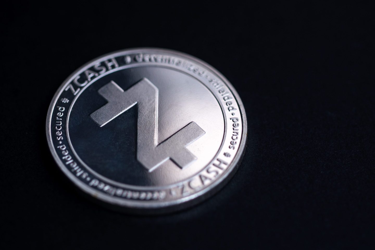 Studio shot of a silver zcash coin against a black backdrop.