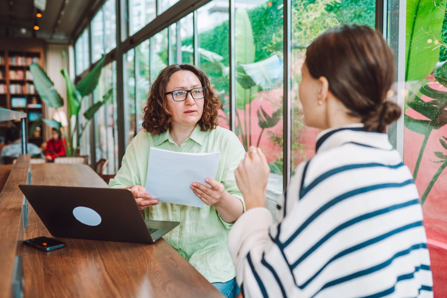 Boss sits with worker to discuss raise at office