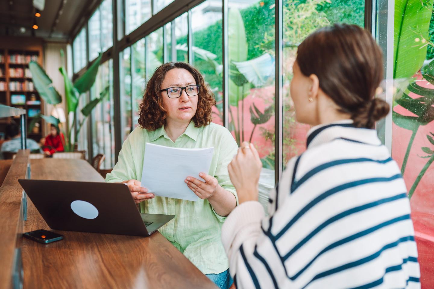 Boss sits with worker to discuss raise at office