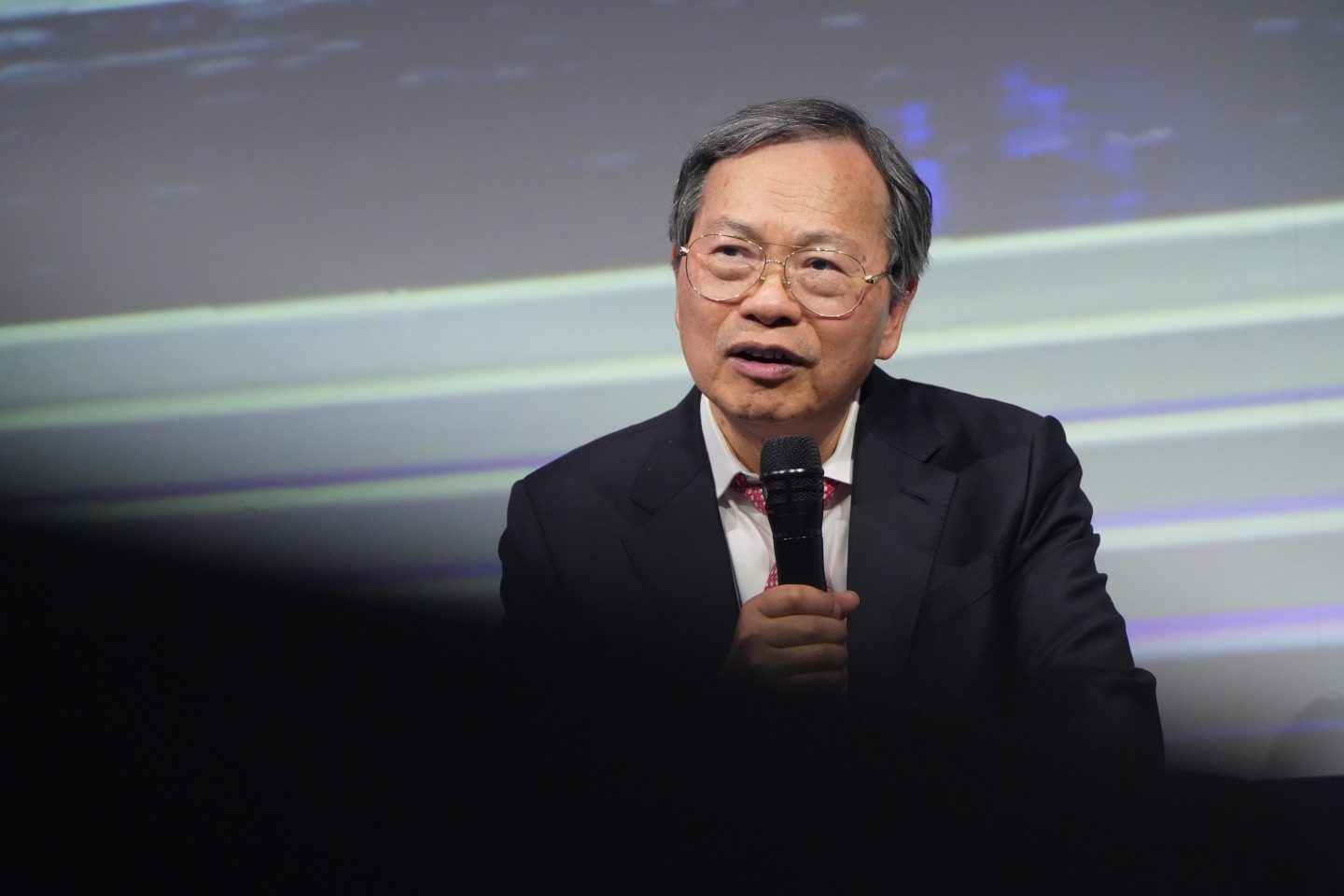 seated man speaks into microphone