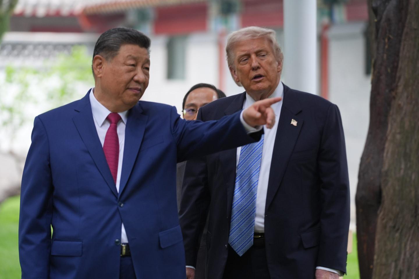 Xi Jinping, standing next to Donald Trump, points to his left.