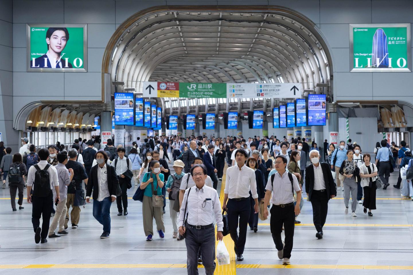 Commuters walk through Shinagawa Station