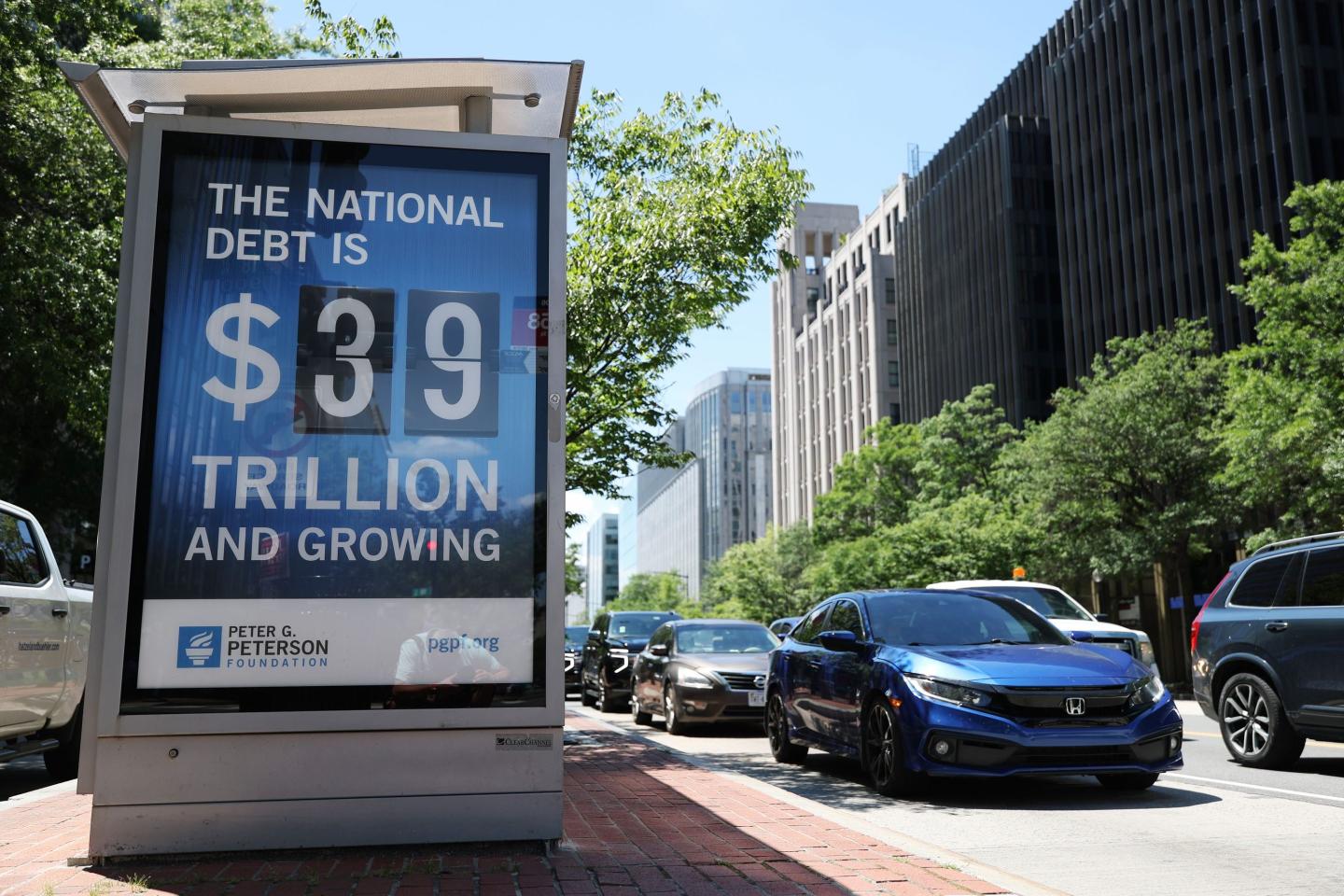 A sign on a bus stop displays the national debt on June 12, 2026, in Washington, D.C.