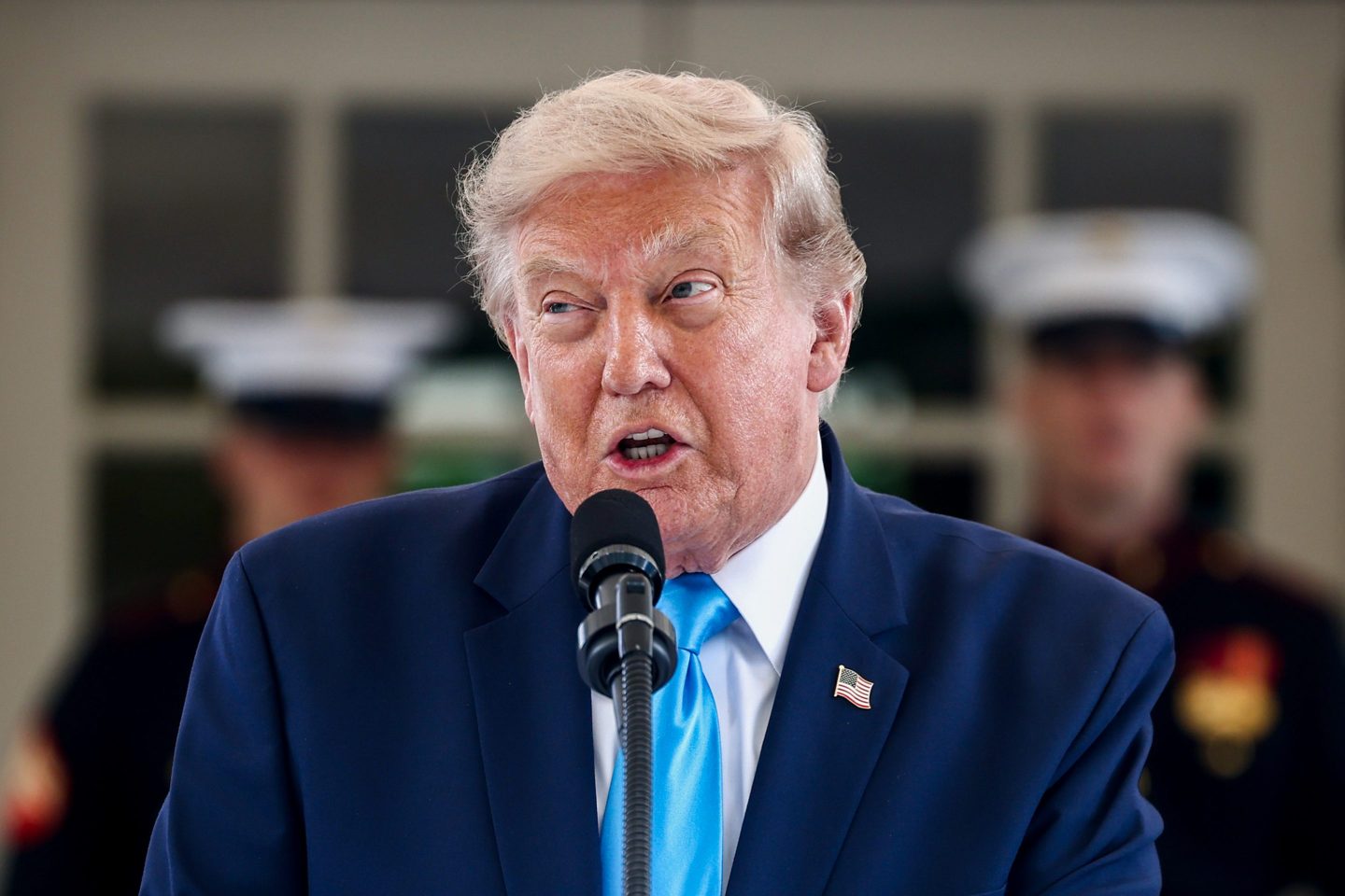 Donald Trump speaks into a microphone.