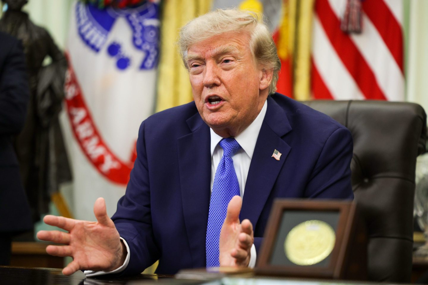 President Trump speaking from the Oval Office with his hands spread apart.