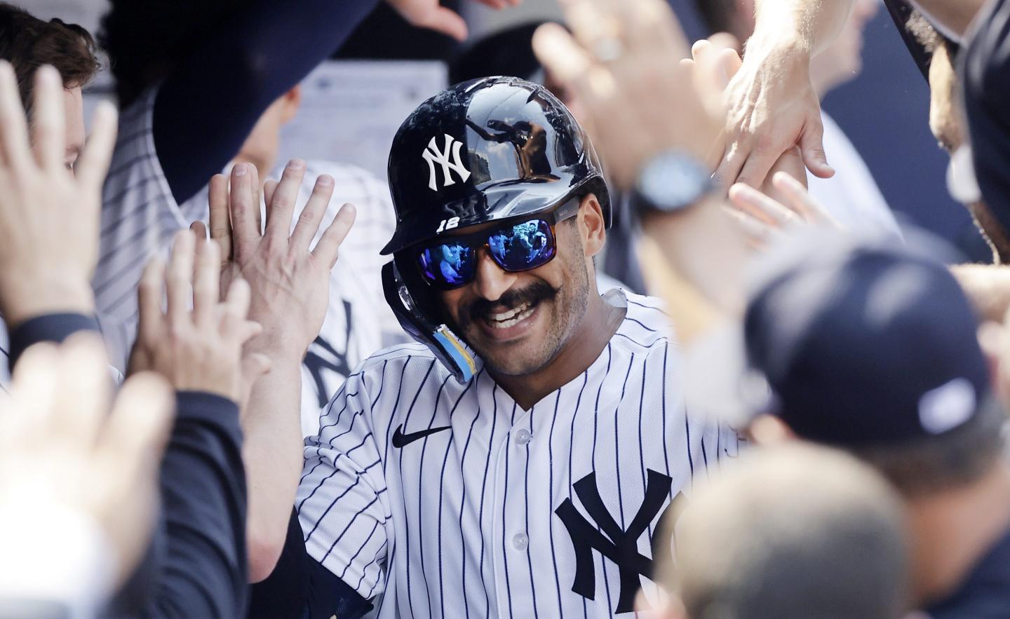Trent Grisham #12 of the New York Yankees celebrates his eighth inning home run against the Atlanta Braves with his teammates in the dugout.