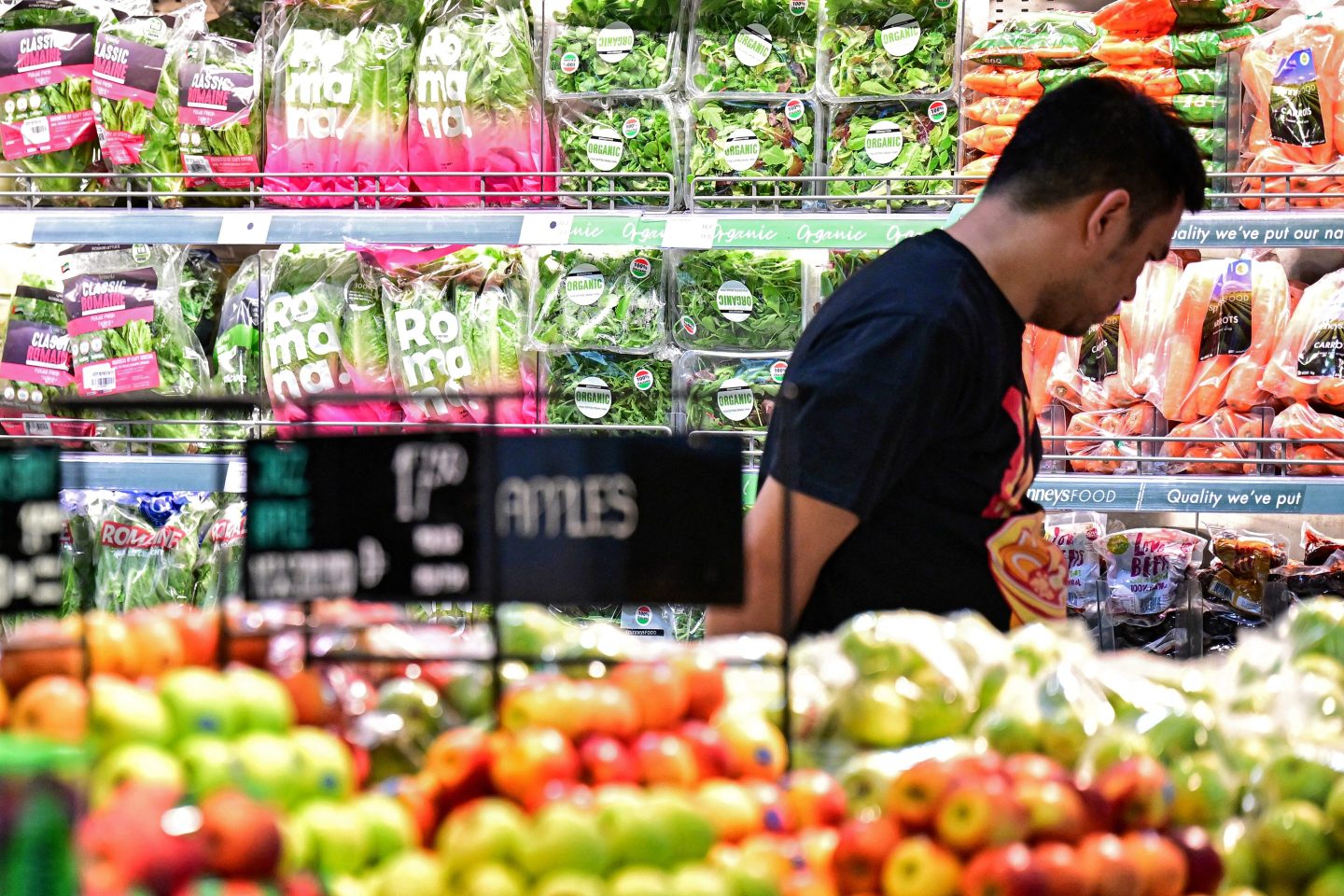 A man shops for produce in a supermarket.