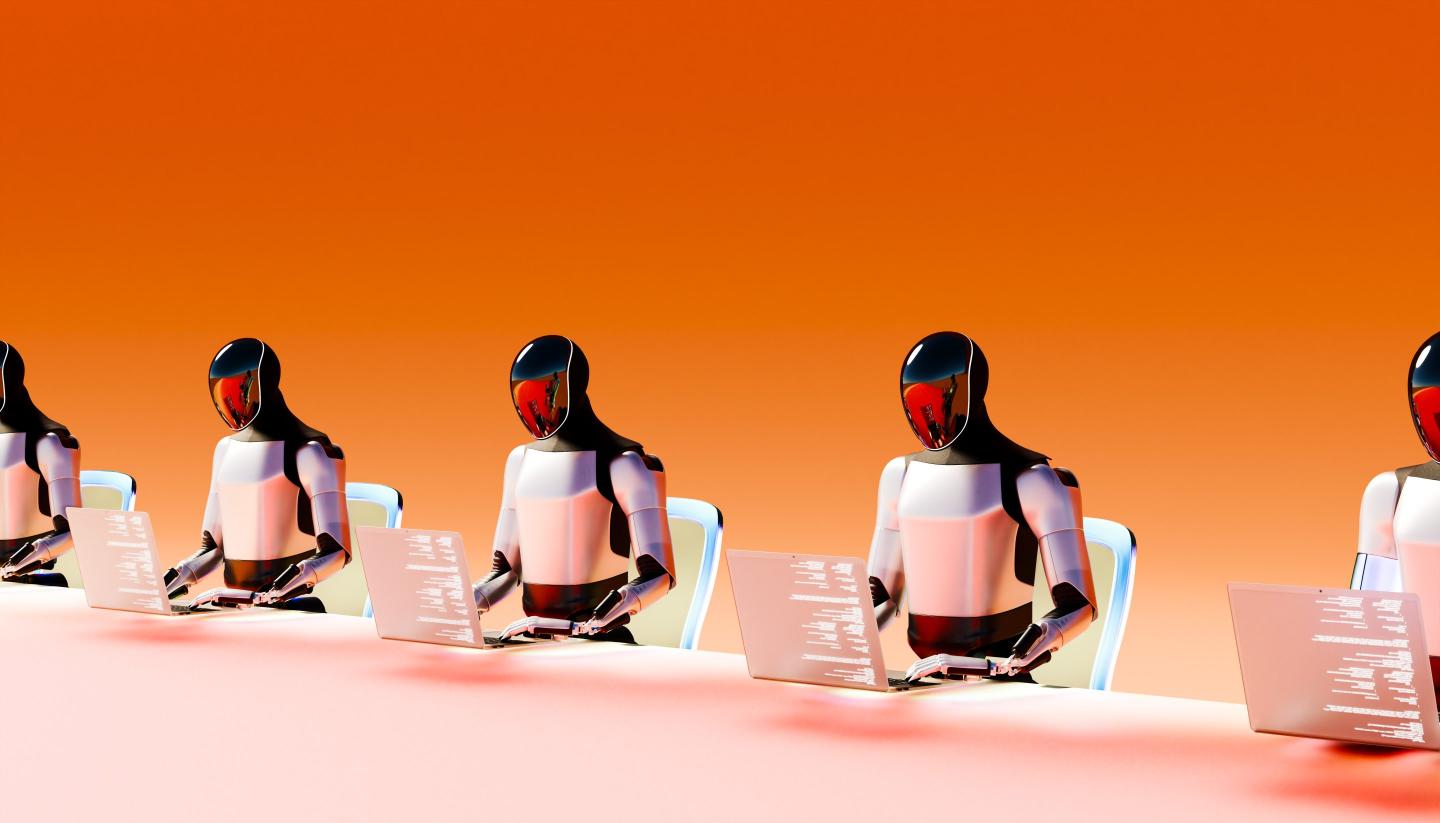 A row of humanoid robots typing into computers against an orange backdrop.