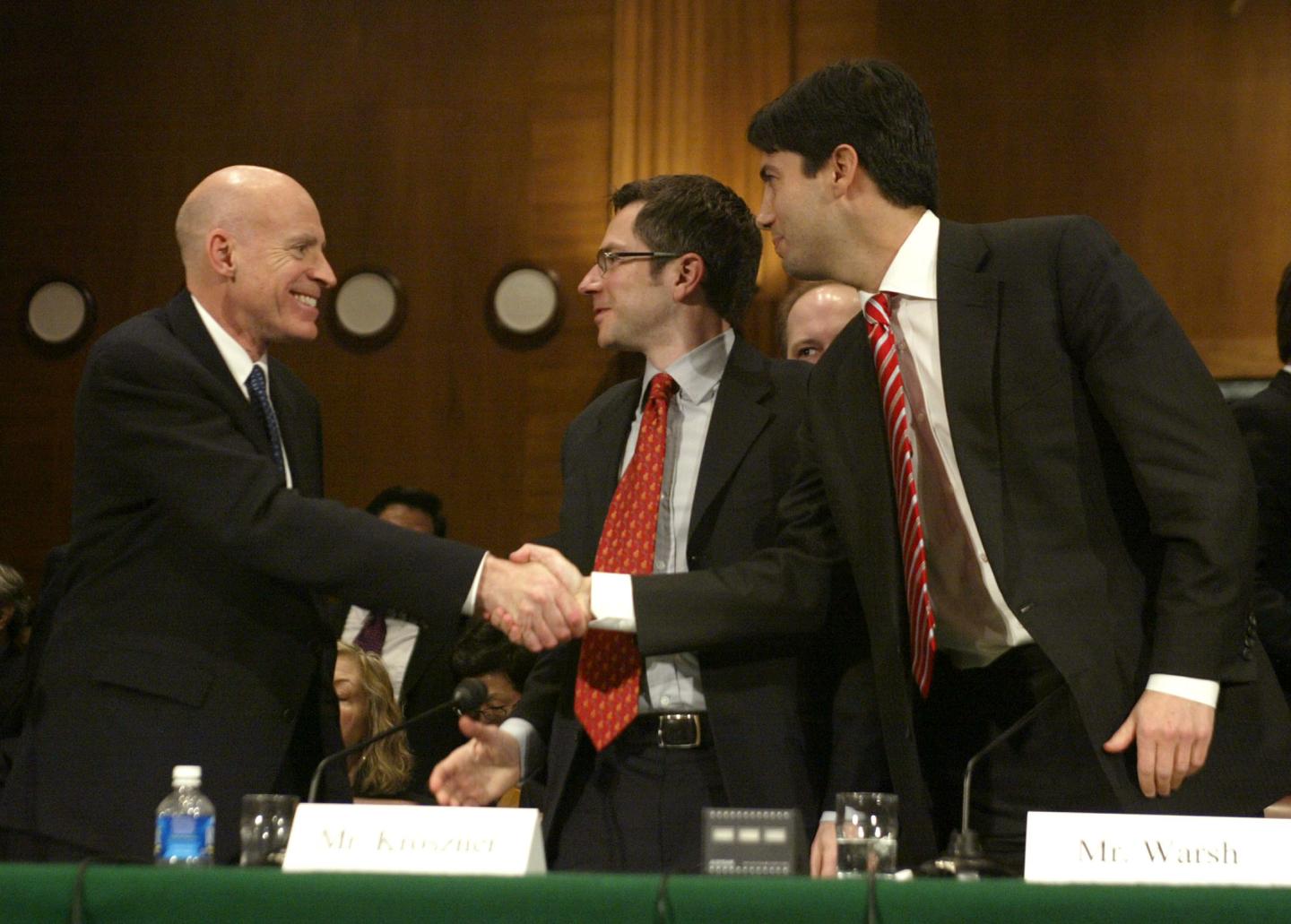 Edward P. Lazear, left, congratulates Randall S. Kroszner, center and Kevin M. Warsh, right, at the conclusion of their confirmation hearing held by the Senate Banking, Housing and Urban Affairs Committee in Washington, DC, February 14, 2006.