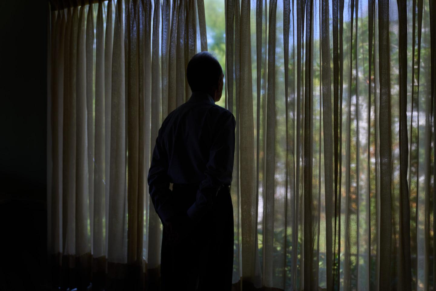 Simon, who was targeted by a scammer that stole $800,000 from his retirement savings and asked not to be identified by his full name because he's too ashamed to tell most of his family about the crime, looks out a window from his home.