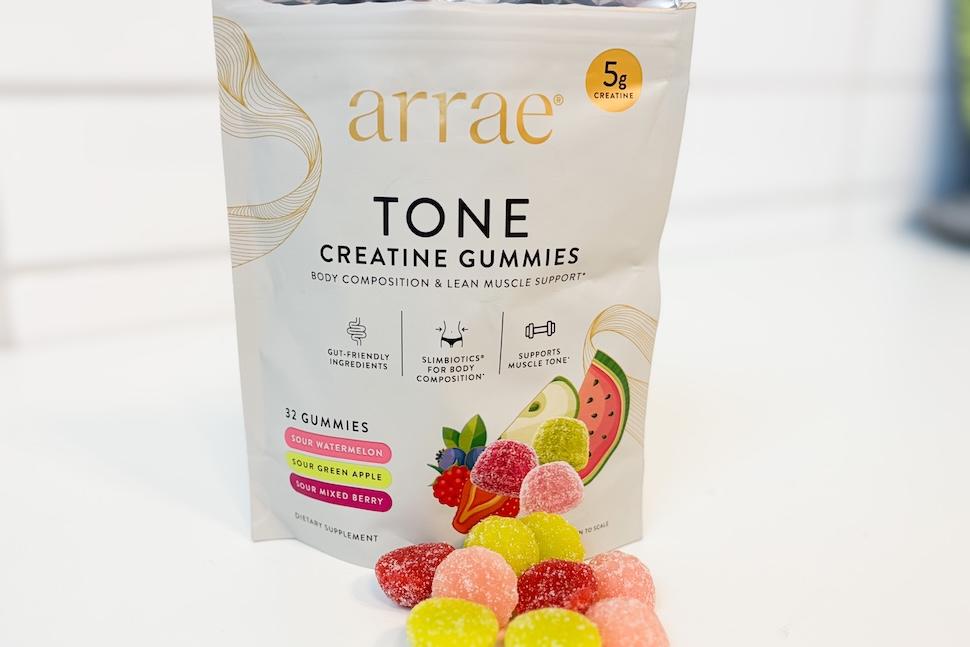 A bag of Tone Arrae gummies sitting on a white countertop. Several of the gummies are out of the bag and piled in front of it.